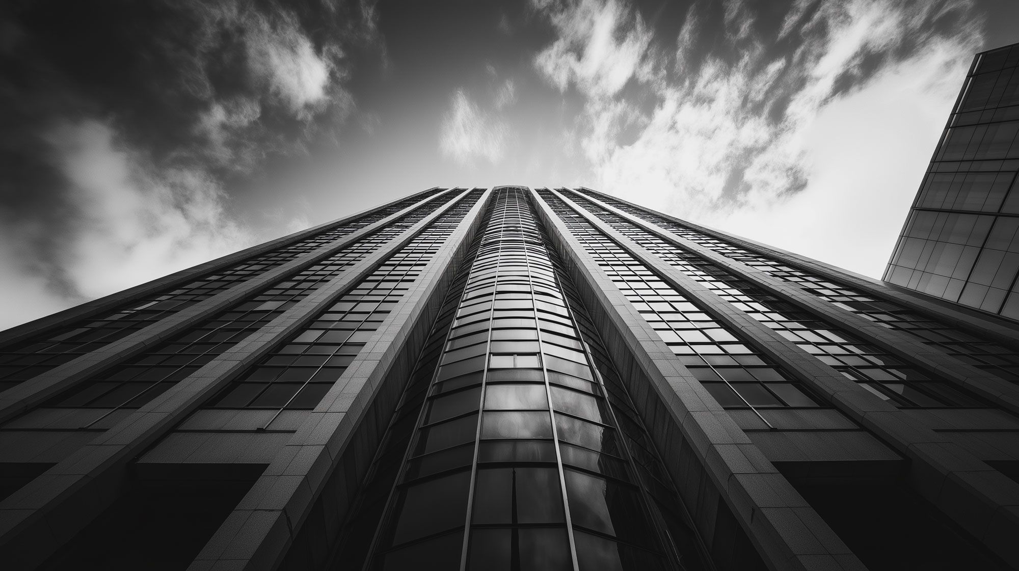 Looking up at an office tower against a cloudy sky